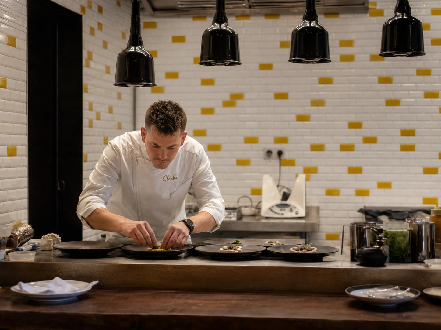 Chef dresseert borden in de open keuken